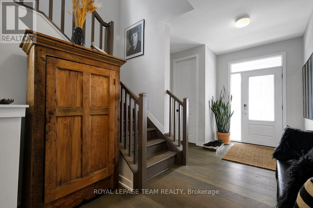 A wooden staircase with a white railing and a potted plant on the landing.