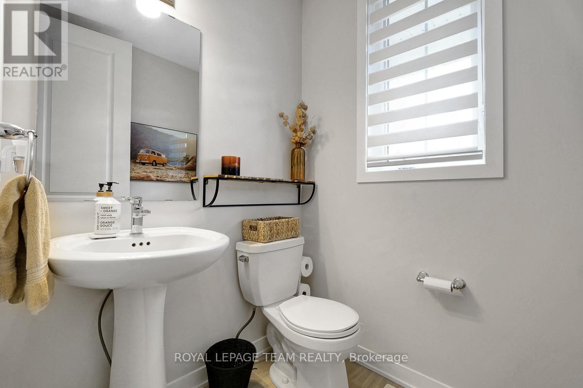 A white bathroom with a toilet, sink, and a mirror.