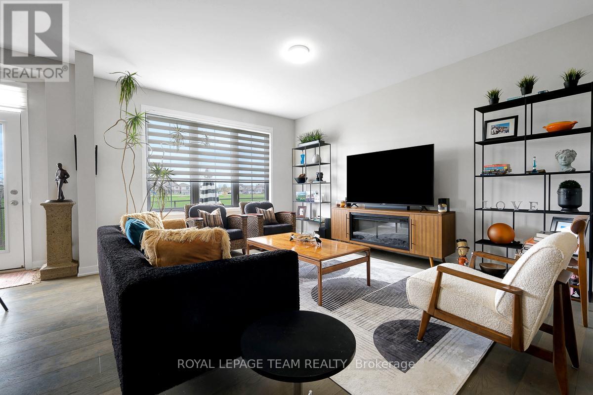 A living room with a black couch, a wooden coffee table, and a TV on a wooden stand.