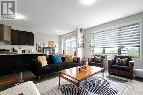 A living room with a black couch and a wooden coffee table.