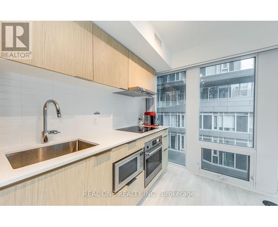 A modern kitchen with wooden cabinets and stainless steel appliances.