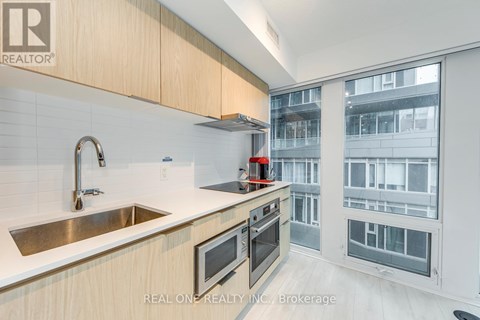 A modern kitchen with wooden cabinets and stainless steel appliances.