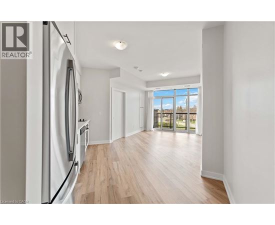 A modern kitchen with a refrigerator and wooden flooring.