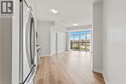 A modern kitchen with a refrigerator and wooden flooring.