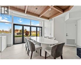 A dining room with a table and chairs and a view of the outside.