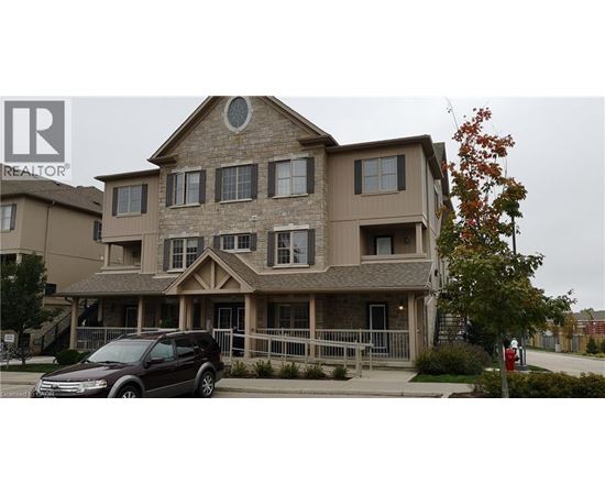 A brown house with a car parked in front.
