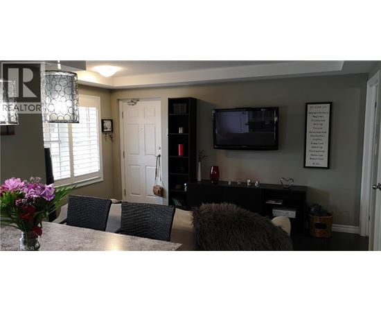 A living room with a grey couch and a black entertainment center.