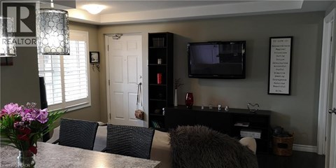 A living room with a grey couch and a black entertainment center.