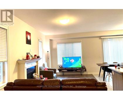 A living room with a fireplace and a television on.