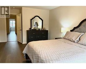 A bedroom with a bed, dresser, and mirror.