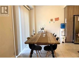 A dining room with a long table and chairs.