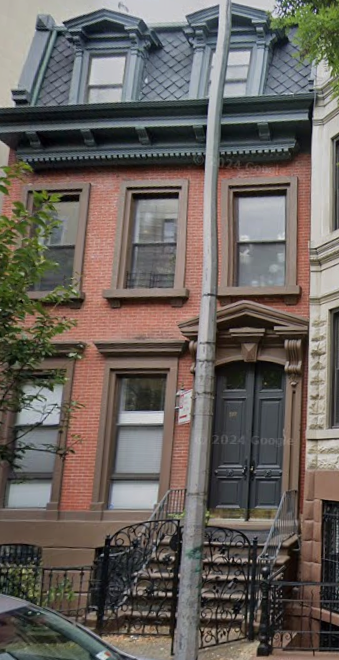 A brick building with a black door and windows.