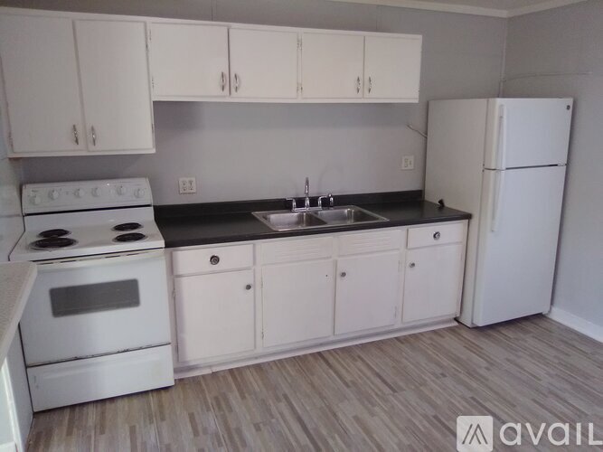 A kitchen with white appliances and cabinets.