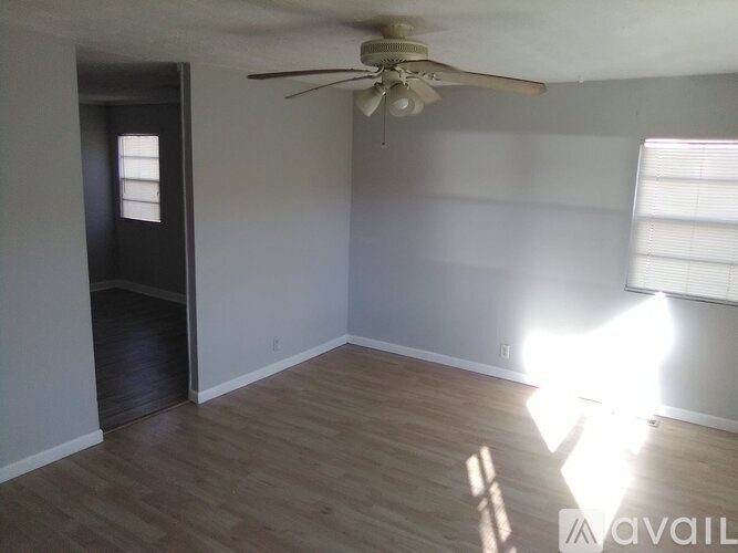 A room with a ceiling fan and a door leading to a hallway.