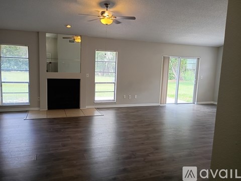 A spacious living room with a black television and wooden flooring.