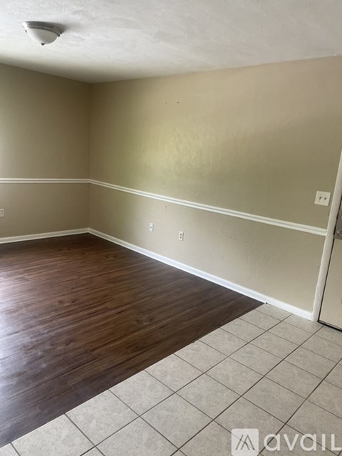 A room with wooden flooring and beige walls.