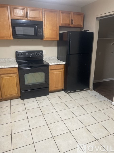 A kitchen with black appliances and wooden cabinets.