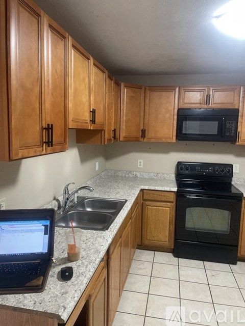 A kitchen with wooden cabinets and a black stove top oven.