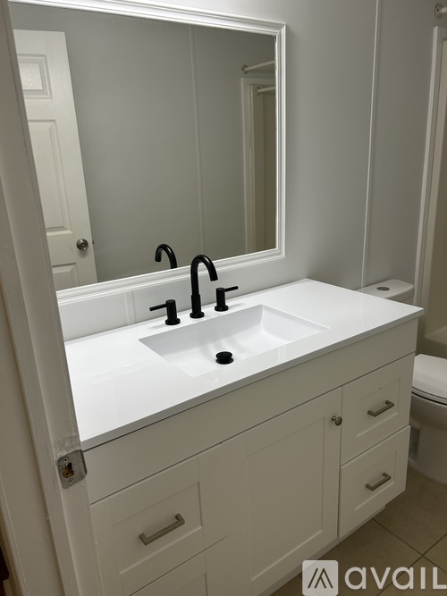 A white bathroom sink with a black faucet.