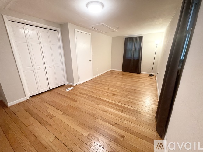 A room with wooden flooring and white walls.