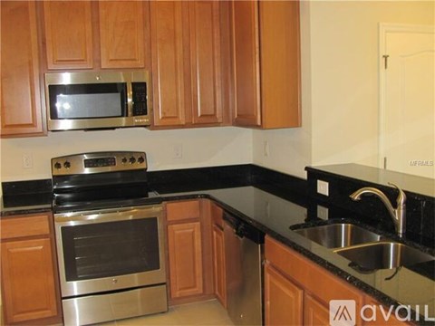 A kitchen with wooden cabinets and black countertops.