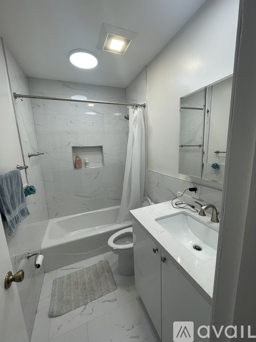 A bathroom with a white tub, sink, and toilet.