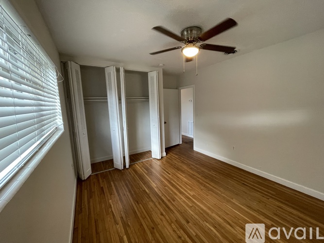 A room with a ceiling fan and wooden flooring.
