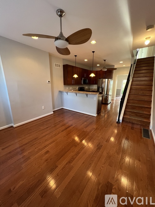 A room with wooden floors and a ceiling fan.