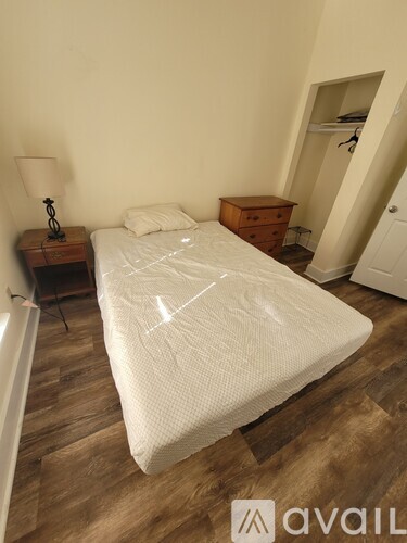 A bedroom with a large bed and a wooden dresser.