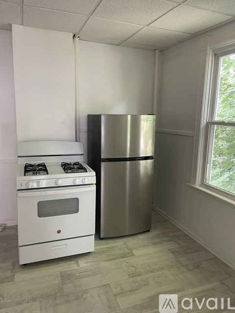 A white stove and a silver refrigerator in a kitchen.