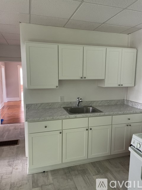 A kitchen with white cabinets and a marble countertop.