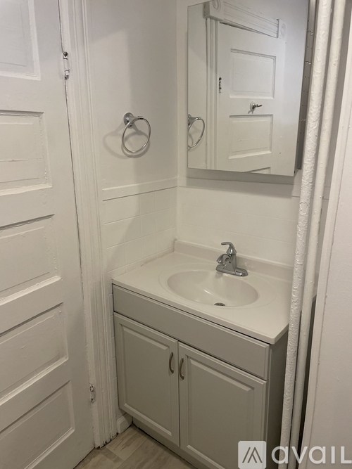 A white bathroom with a sink and a mirror.