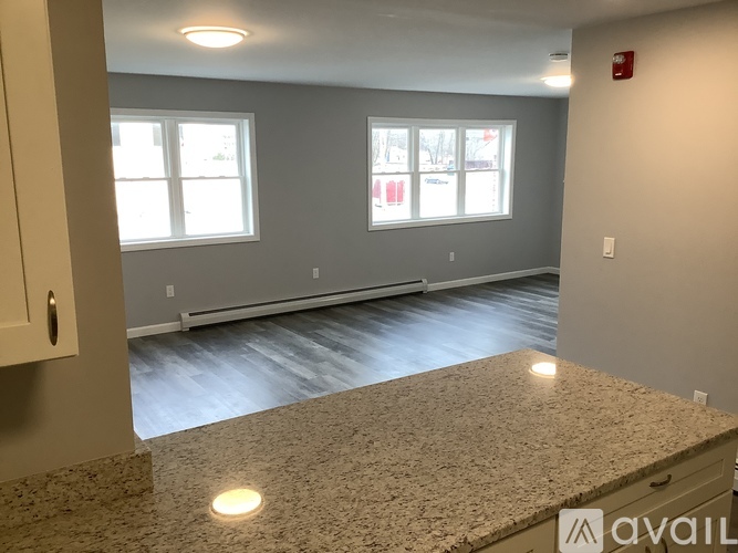 A room with a granite countertop and two windows.