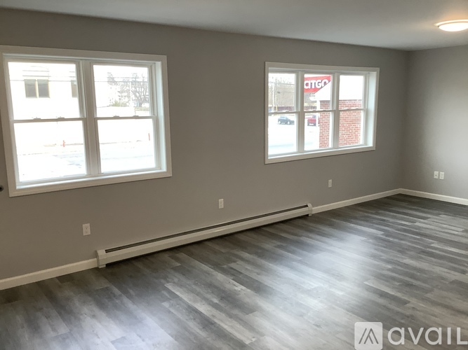 A room with a grey floor and two windows.