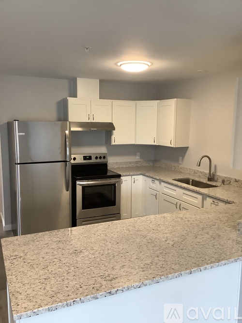 A kitchen with a granite countertop and stainless steel appliances.