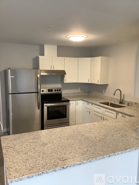 A kitchen with a granite countertop and stainless steel appliances.