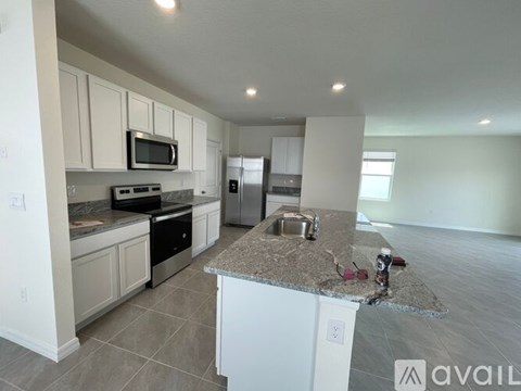 A kitchen with granite countertops and white cabinets.