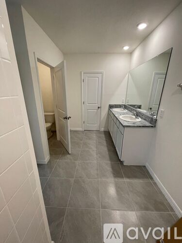 A bathroom with a sink, mirror, and toilet.