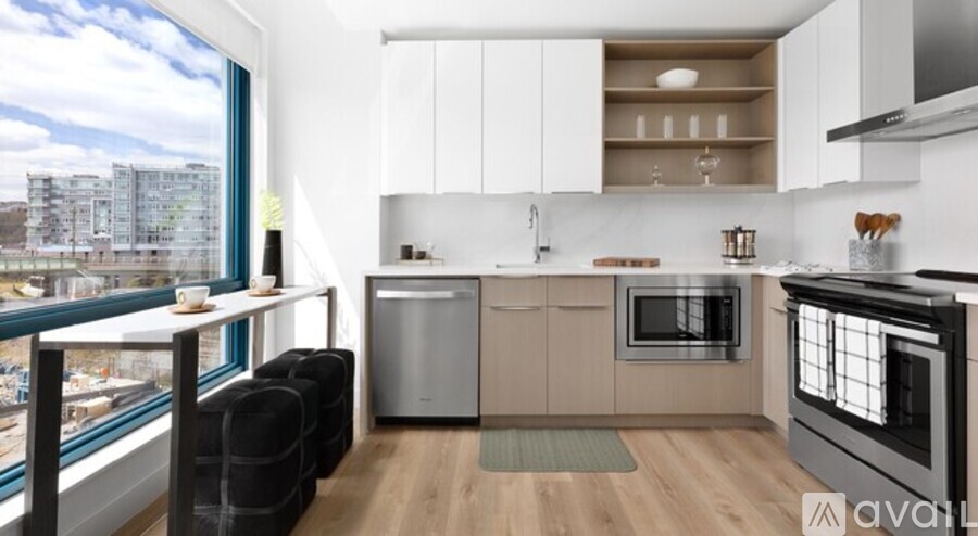 A kitchen with a large window overlooking a cityscape.