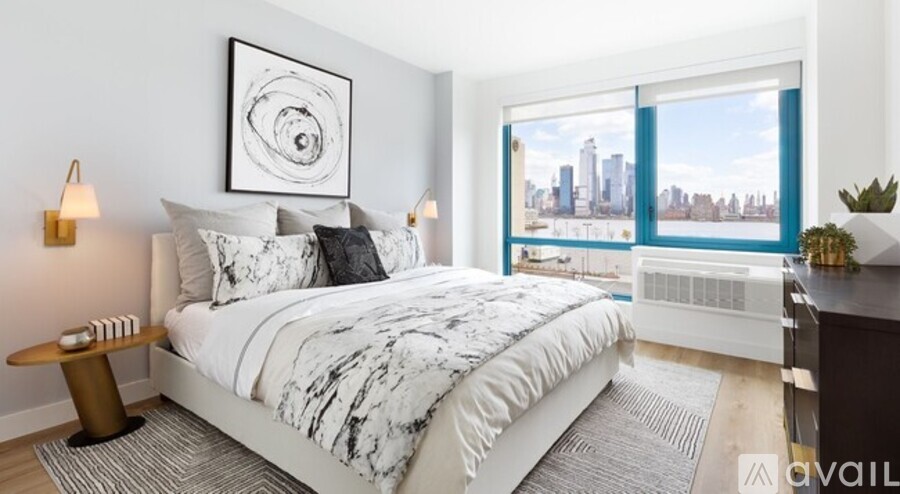 A bedroom with a large bed and a city view through the window.
