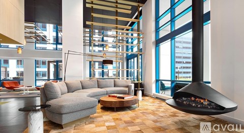 A modern living room with a large grey sectional sofa and a fireplace.