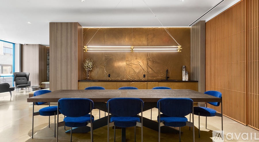 A conference room with a long table and blue chairs.
