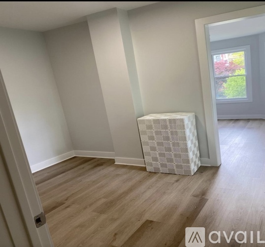 A room with wooden flooring and a white radiator cover.