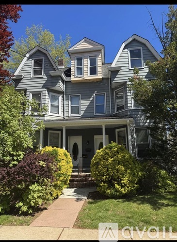A large house with a grey exterior and a front porch.