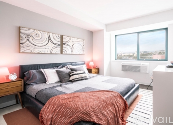 A bedroom with a large bed and a view of the city.