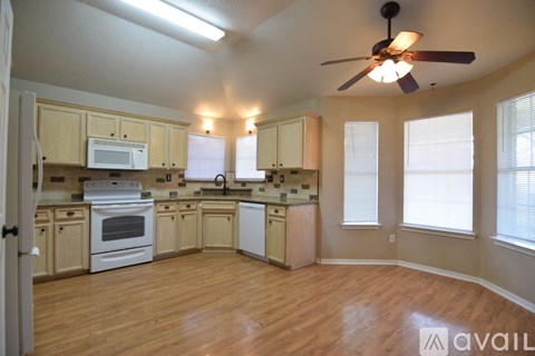 A kitchen with wooden floors and white appliances.