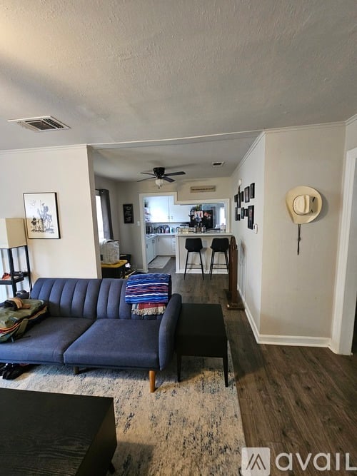 A living room with a blue sofa and a rug.
