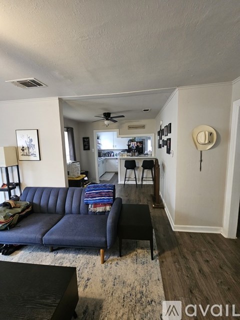 A living room with a blue sofa and a rug.