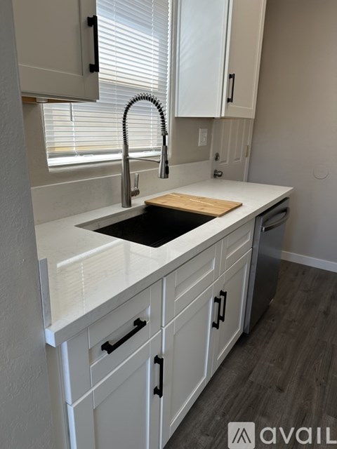 A kitchen with white cabinets and a black sink.