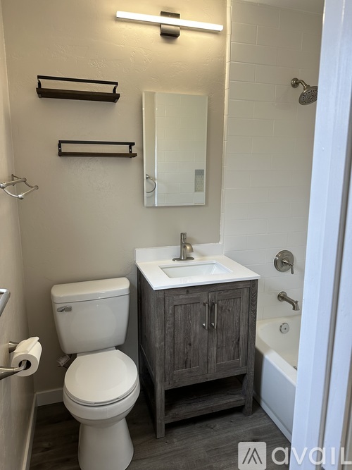 A white toilet sits next to a sink in a small bathroom.
